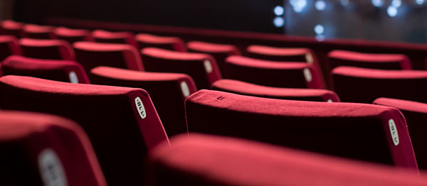 empty red theater seats with number tags